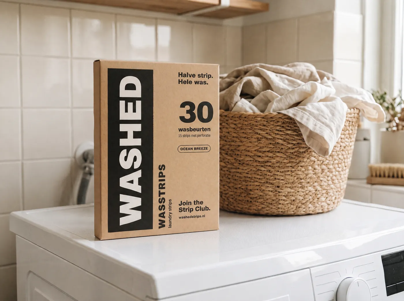 Doos Washed wasstrips op een wasmachine naast een wasmand